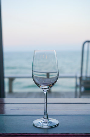empty wine glass on table with sea backgroundの写真素材