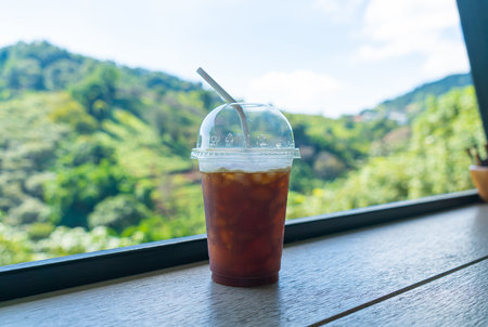 iced black coffee on wood bar with mountain hill backgroundの写真素材