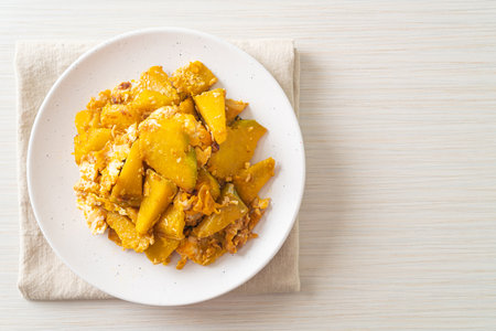 Stir Fried Pumpkin with Egg on white plateの写真素材