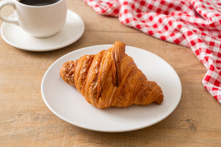 fresh croissant on white plate with black coffeeの写真素材