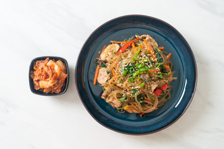 japchae or stir-fried Korean vermicelli noodles with vegetables and pork topped with white sesame - Korean traditional food styleの写真素材