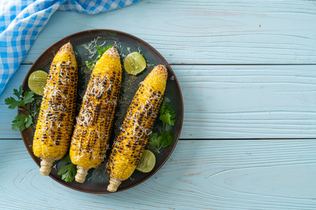 barbecue and grilled corn with cheese and lime on plate