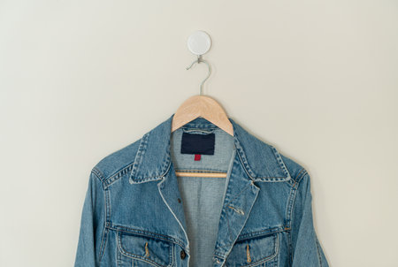 jacket jean hanging with wood hanger on wallの写真素材