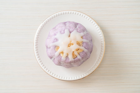 taro bun with white sugar cream and nut on topの写真素材