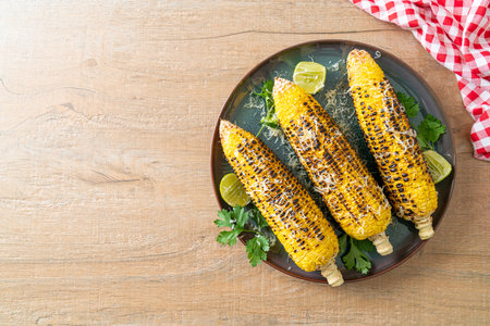 barbecue and grilled corn with cheese and lime on plate