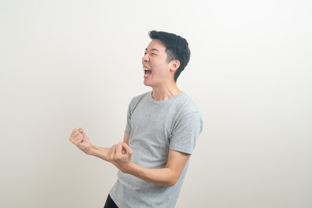 young Asian man with successful action on white backgroundの写真素材