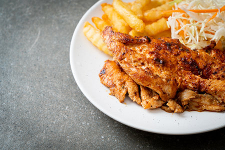 grilled spicy barbecue chicken steak with french friesの写真素材