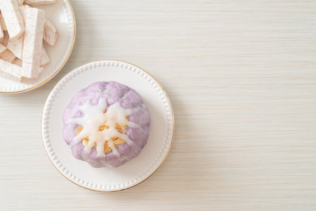 taro bun with white sugar cream and nut on topの写真素材