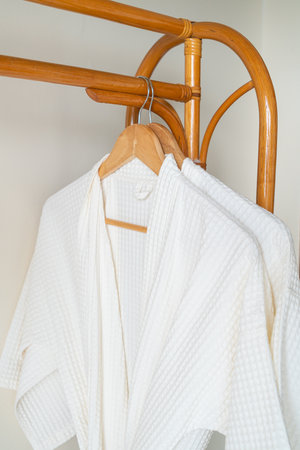 close up white bathrobe hanging in bathroomの写真素材