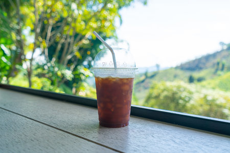 iced black coffee on wood bar with mountain hill backgroundの写真素材