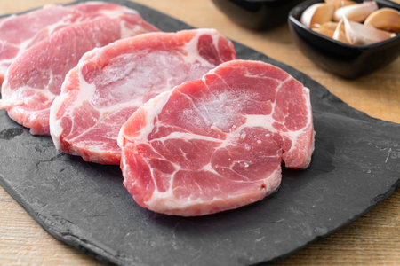 fresh pork neck raw or collar pork on board with ingredients for marinatedの写真素材