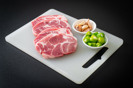 fresh pork neck raw or collar pork on board with ingredients for marinatedの写真素材