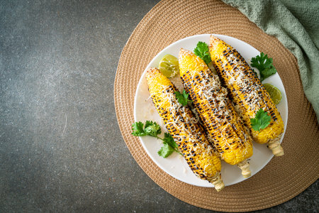 barbecue and grilled corn with cheese and lime on plateの写真素材