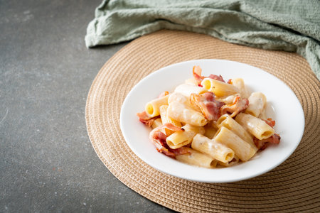 homemade spaghetti rigatoni pasta with white sauce and bacon - Italian food styleの写真素材