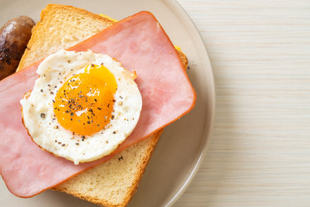 homemade bread toasted ham and fried egg with pork sausage for breakfastの写真素材