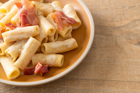 homemade spaghetti rigatoni pasta with white sauce and bacon - Italian food styleの写真素材