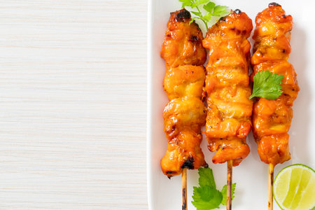 grilled chicken skewer with herbs and spices on plateの写真素材
