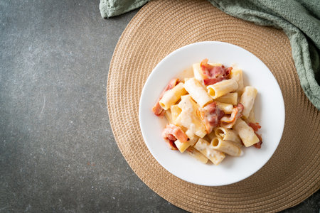 homemade spaghetti rigatoni pasta with white sauce and bacon - Italian food styleの写真素材