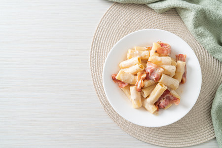 homemade spaghetti rigatoni pasta with white sauce and bacon - Italian food styleの写真素材
