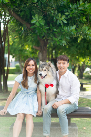 Asian couple love with cute dog in gardenの写真素材