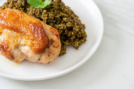 pesto fried rice with grilled chicken on white plateの写真素材