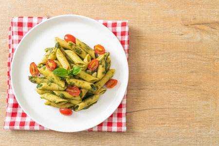 penne pasta with pesto sauce and tomatoes - vegan and vegetarian food styleの写真素材