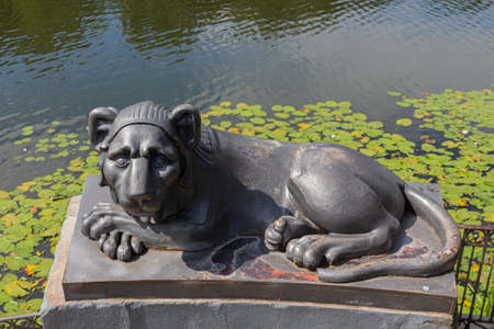 Egyptian sphinx stylized cast-iron sculpture of a lion against a background of a pond with water lilies, Kuzminsky park, Moscowの写真素材