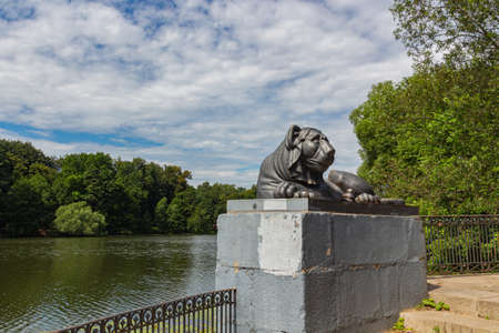 Egyptian sphinx stylized cast-iron sculpture of a lion against a background of a pond, Kuzminsky park, Moscowの写真素材
