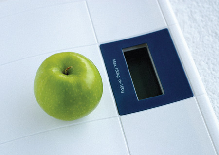 Close-up of a green apple on a weighing scale
