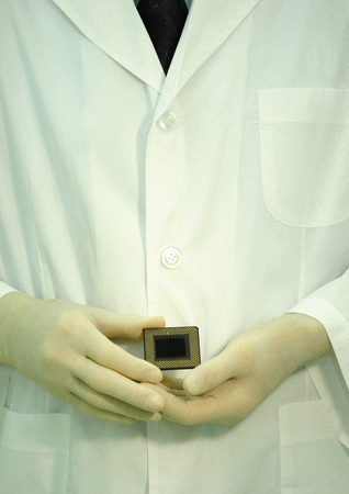Mid section view of a scientist holding a computer processor