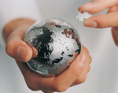 Close-up of a metal jigsaw ball in a man's handsの写真素材