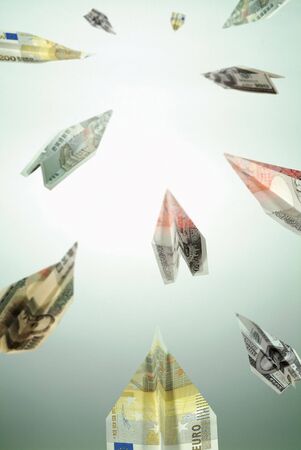 Low angle view of paper planes made from currency notesの写真素材