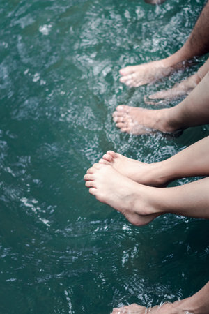 Family summer trip, relaxing with legs in water.の写真素材
