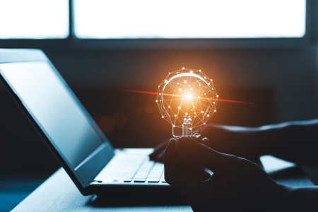 Hand holding a light bulb and working on a laptop computer, Concept of inspirational ideas creativity and technological innovation of the future.の写真素材