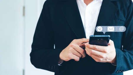 Hand of Businessman holding mobile smartphone. Contact Us, customer support concept. copy space.の写真素材