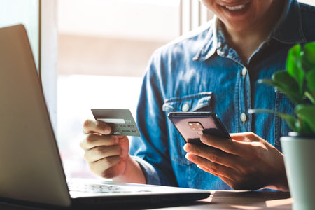 Men use credit cards to shop online and pay online or in digital banking on their smartphones at home.の写真素材