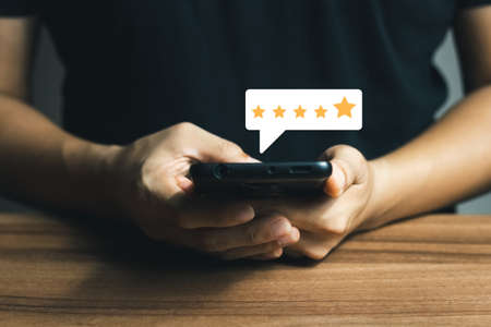 User give rating to service experience on online application, Customer review satisfaction feedback survey concept, Customer can evaluate quality of service leading to reputation ranking of business.の写真素材