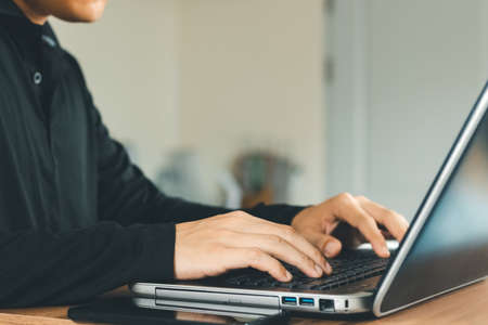 young man using  laptop computer and  mobile phone When looking for financial information in...