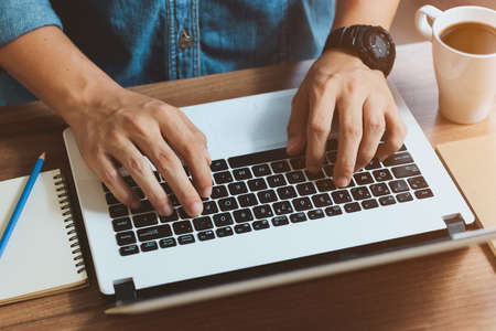 Website developer working using laptop at office on wooden.の写真素材