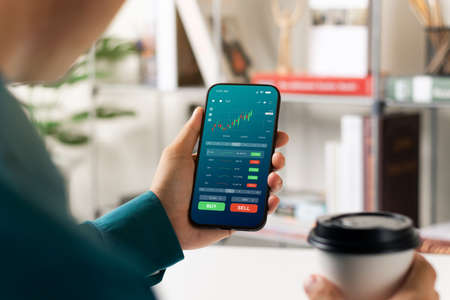 Businessmen work with stock market investments using smartphones to analyze trading data. smartphone...
