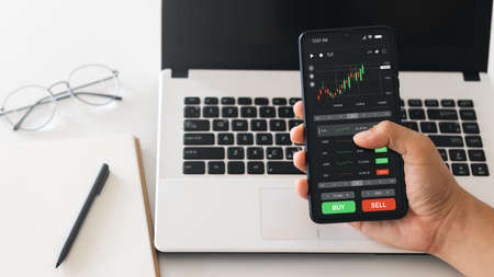 Businessmen work with stock market investments using smartphone to analyze trading data. smartphone...