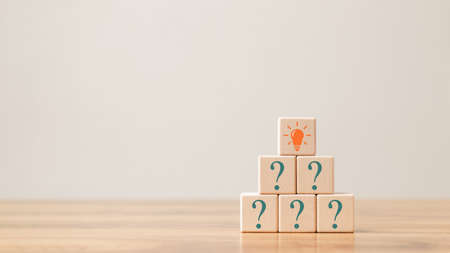Creative concept. Think different, wooden cube with question mark and light bulb sign.