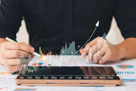 Businessmen work with stock market investments using tablets to analyze trading data. smartphone...