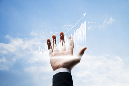 Businessman hand holding graph analysis of finance and investments, stock market and banking, financial plans and digital economy strategies, The acquisition of shares of a growing company in the future.の写真素材