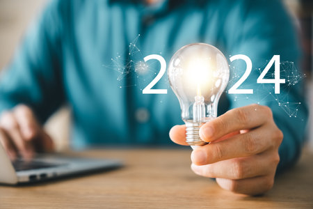 2024 creative concept, business man holding light bulb 2024 numbers, 2024 trend leader, setting goals for future business.の写真素材