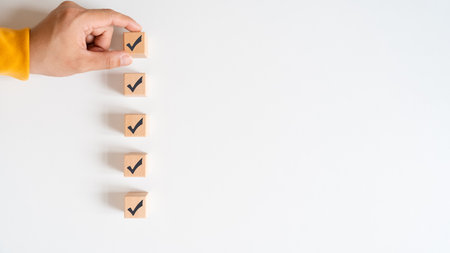 Checklist concept, wooden cubes with check marks on white table. Checklist, form filled in business.の写真素材