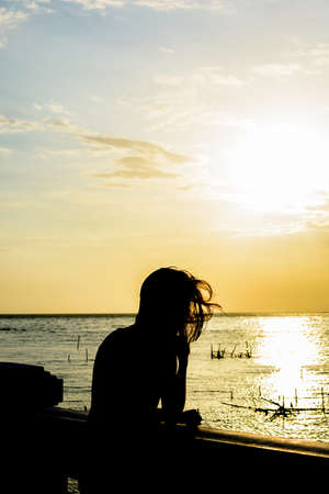 woman under the sunset at seaの写真素材
