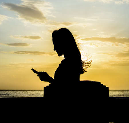 woman under the sunset at seaの写真素材