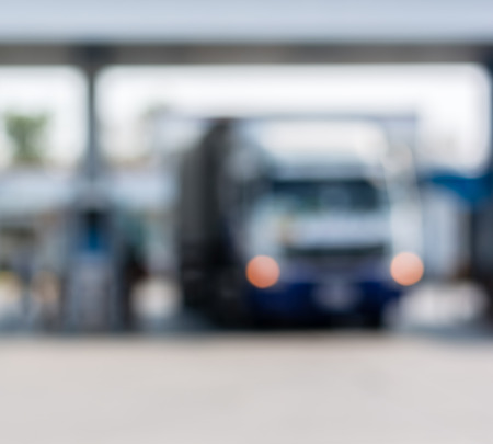 Blurred gas station with bus and truck