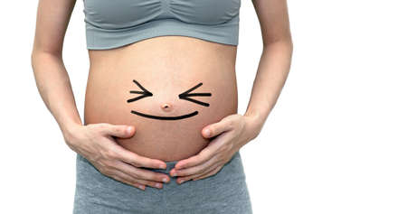 Close up of a cute pregnant belly. Isolated on white background with copy spaceの写真素材
